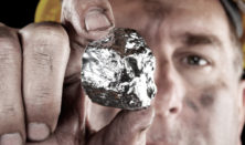 a miner holding up a nugget of silver